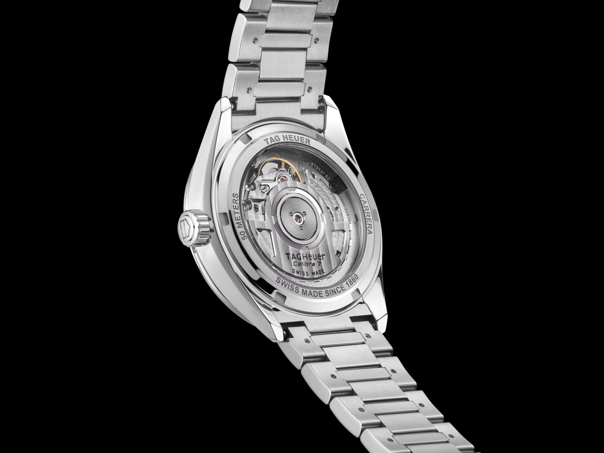 Nahaufnahme der Rückseite einer TAG Heuer Carrera Date mit Edelstahlarmband, mit transparentem Gehäuseboden und sichtbarem mechanischem Uhrwerk vor schwarzem Hintergrund.