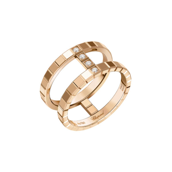 Der Chopard Ring Ice Cube ist ein doppelreihiger Goldring mit vier quadratisch gefassten Diamanten auf der Oberseite, gravierten Details entlang der Ringe und der Aufschrift "Chopard" im Inneren. Er wird auf weißem Hintergrund präsentiert.