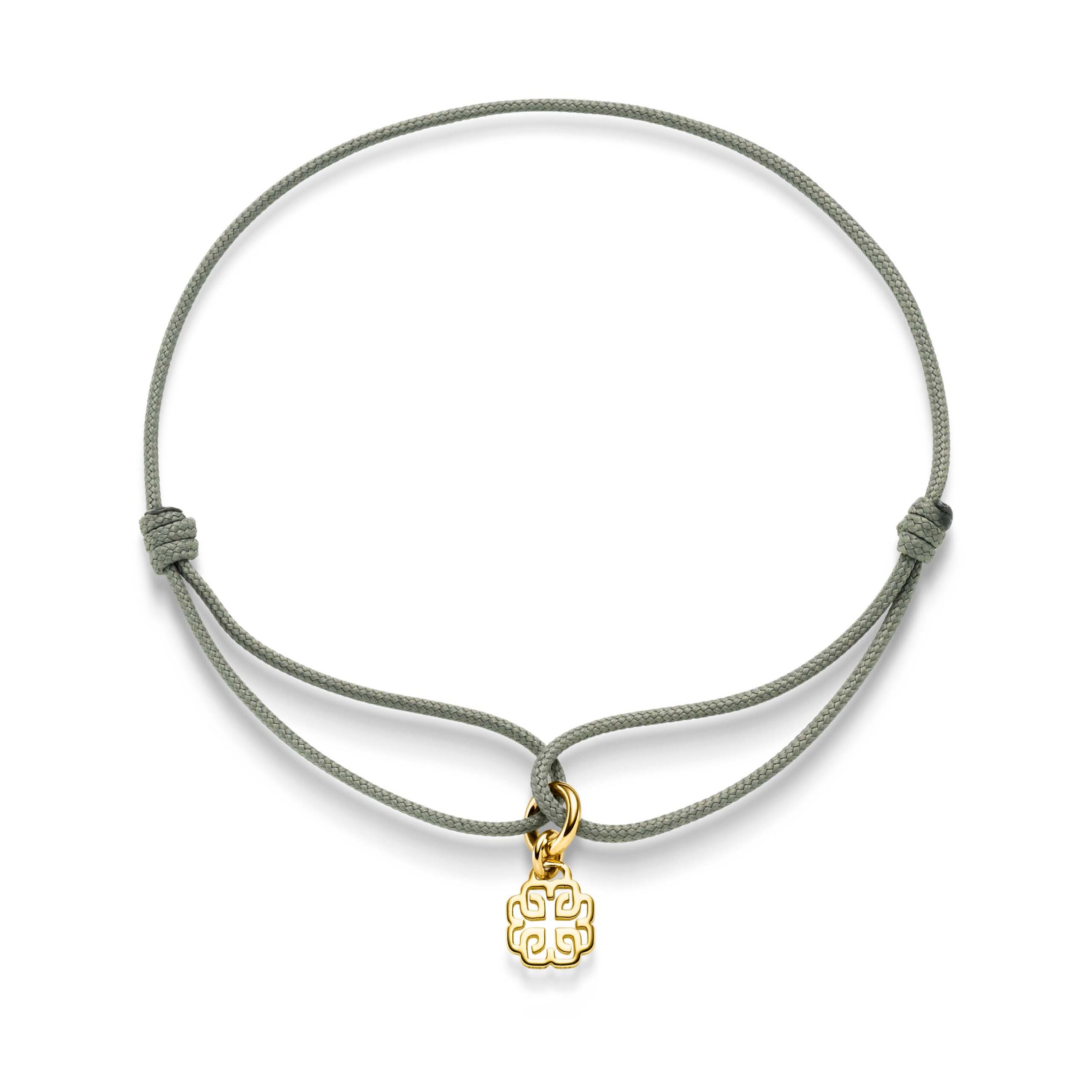 Das „Binder Signature“ in Khaki (14,5 cm) ist ein schlichtes Armband aus Khaki-Kordel mit verstellbaren Knoten, das in der Mitte mit einem kleinen goldenen Anhänger mit filigranem Ausschnitt verziert ist.