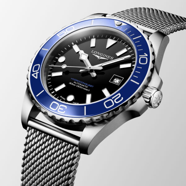 Eine Nahaufnahme der Longines HydroConquest Edelstahlarmbanduhr mit blauer Lünette, schwarzem Zifferblatt, weißen Indexen, Metallarmband, Datumsanzeige und auffälligen Leuchtzeigern.