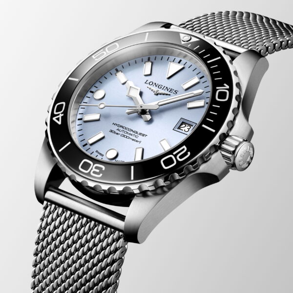 Eine Nahaufnahme der Longines HydroConquest Uhr mit hellblauem Zifferblatt, silbernen Indexen, schwarzer Lünette, Datumsfenster bei 3 Uhr und Edelstahlarmband vor einem hellen Hintergrund.