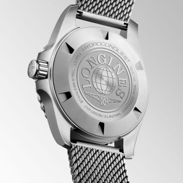 Nahaufnahme des Bodens der Longines HydroConquest-Uhr mit eingraviertem Markenzeichen, Weltkugel-Design und Edelstahl-Meshband. Das Gehäuse weist auf die Wasserdichtigkeit und die Konstruktion aus Edelstahl hin.