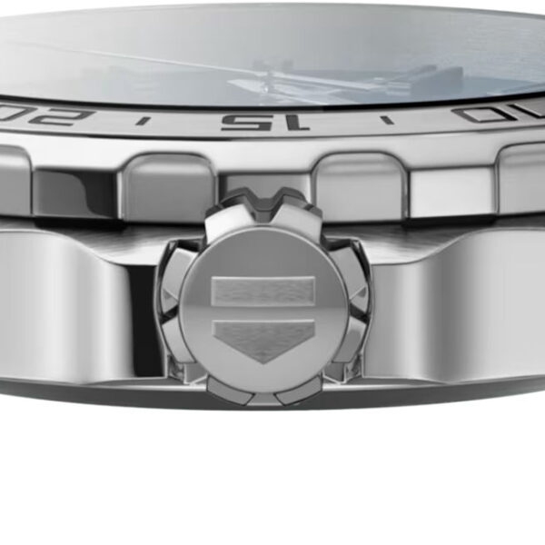 Seitenansicht einer silbernen TAG Heuer Formula 1-Armbanduhr aus Metall mit geriffelter Lünette, Krone mit Schildlogo und Metallgliederarmband. Nur der Rand des Ziffernblatts ist sichtbar.