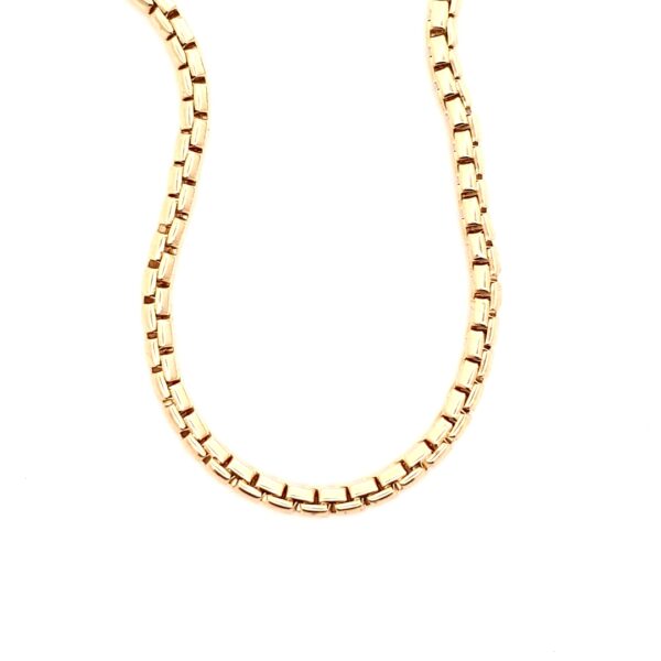 Eine Nahaufnahme der Elaine Firenze Kette, einer goldenen Kette mit rechteckigen Gliedern, elegant geschwungen vor einem weißen Hintergrund.