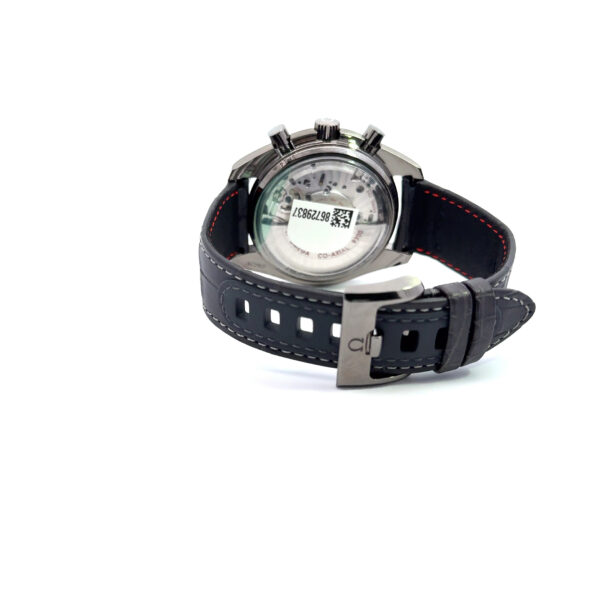Die OMEGA Speedmaster Grey Side of the Moon Armbanduhr verfügt über ein schwarzes Lederarmband, eine silberne Dornschließe und einen Ausstellungsboden mit einem QR-Code und einer Seriennummer, die auf weißem Hintergrund angezeigt werden.