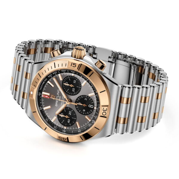 Der Breitling Chronomat II B01 Chronograph 42 verfügt über ein silbernes und roségoldenes Metallband, ein schwarzes Zifferblatt mit drei Hilfszifferblättern, goldene Zeiger und eine roségoldene Lünette mit Minutenanzeige für einen luxuriösen Look.