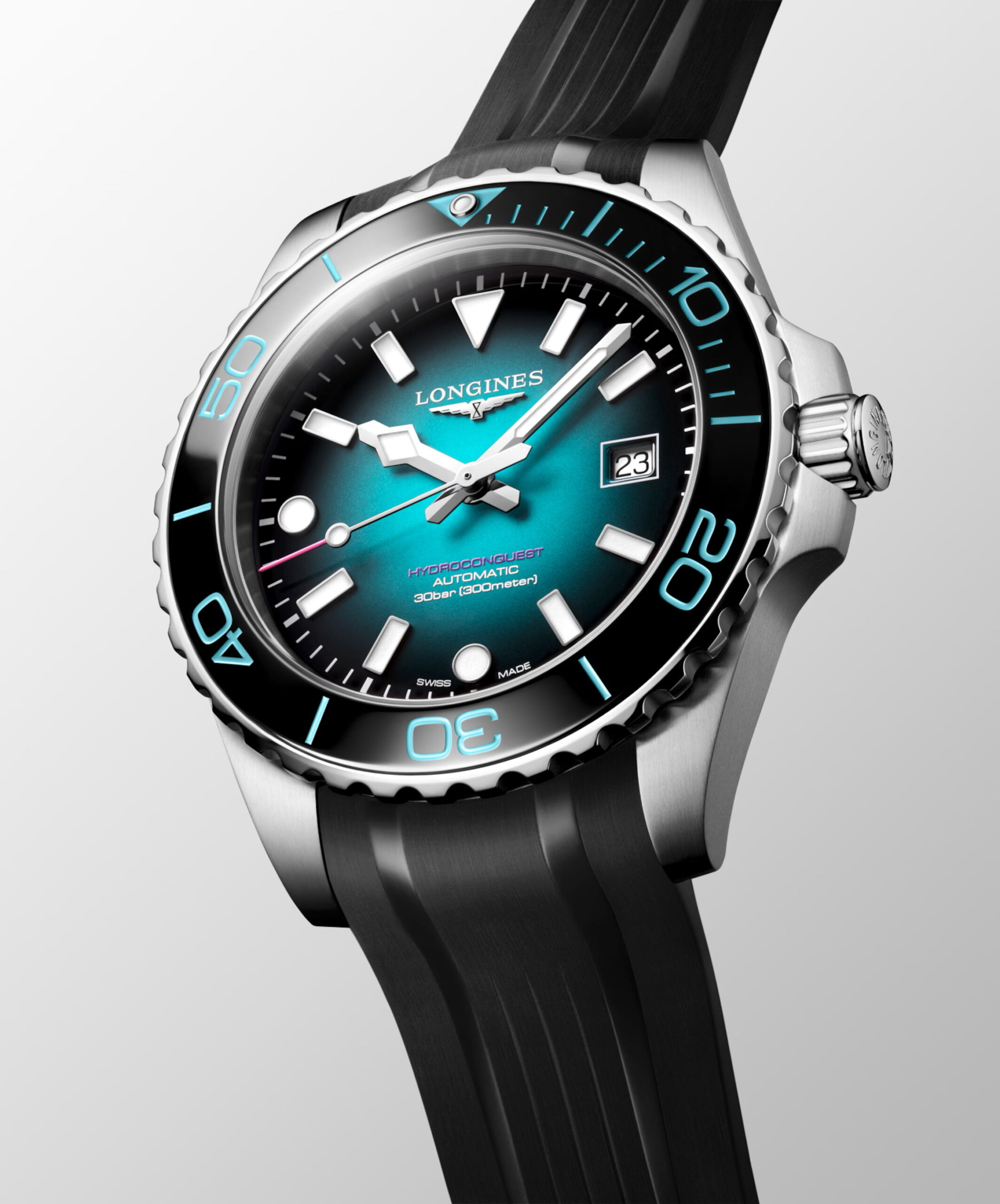 Eine Nahaufnahme der Longines HydroConquest Commonwealth Games 2026 Uhr mit teal-schwarzem Zifferblatt mit Farbverlauf, auffälligen weißen Indexen, Datumsfenster bei 3 Uhr, silberner Lünette und schwarzem Kautschukarmband vor hellem Hintergrund.