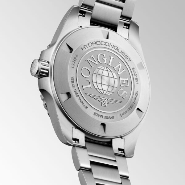 Auf dem Gehäuseboden einer Longines HydroConquest Quarz-Uhr aus Edelstahl sind eine Gravur, ein Globus-Motiv und ein Metallarmband zu sehen, die sich alle vor einem hellgrauen Hintergrund abheben.