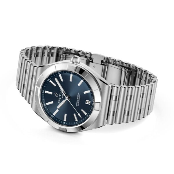 Die Breitling Chronomat II Automatic 36 verfügt über ein Edelstahlgehäuse, ein blaues Zifferblatt, silberne Indexe, das Datum bei 6 Uhr und ein poliertes Metallgliederarmband auf weißem Grund.