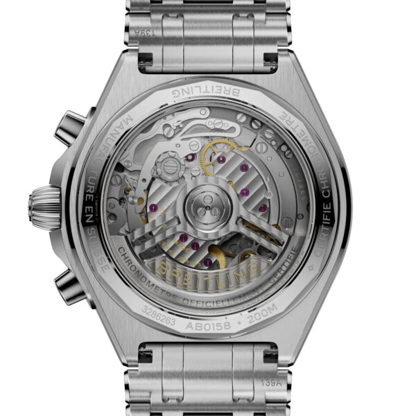 Nahaufnahme des Bodens der Breitling Chronomat B01 Chronograph 42, die durch einen transparenten Gehäuseboden das komplizierte mechanische Uhrwerk, den gravierten Rotor und die Zahnräder sowie das Edelstahlarmband und die detaillierten Gravuren zeigt.