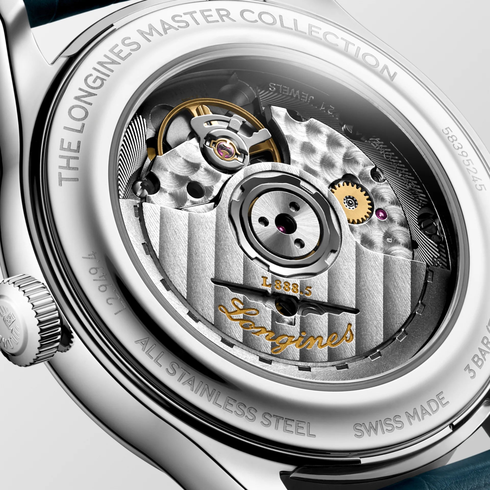 Nahaufnahme des mechanischen Uhrwerks der Longines Master Collection, die durch einen transparenten Gehäuseboden mit eingravierten Markierungen und dem goldenen Longines"-Schriftzug die Details der Zahnräder und Komponenten zeigt.