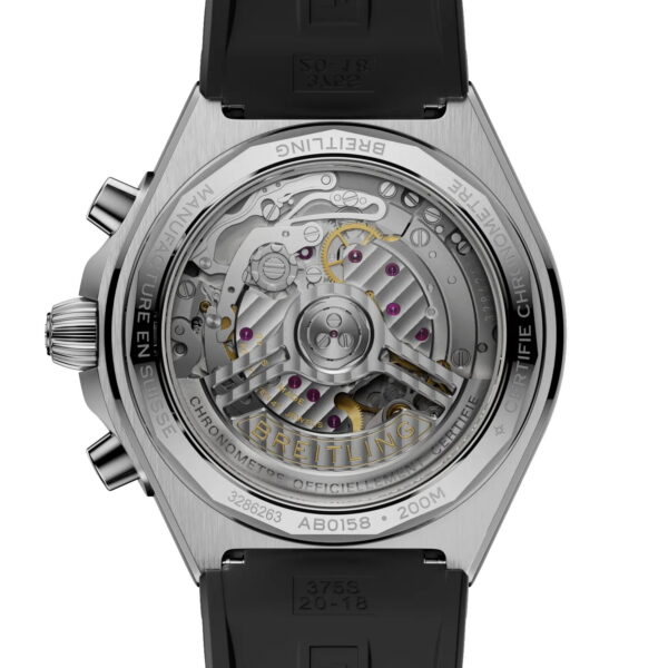 Eine Nahaufnahme des Gehäusebodens der Breitling Chronomat B01 Chronograph 42 zeigt ein transparentes Gehäuse, durch das Zahnräder und Mechanismen sichtbar sind. Der Gehäuseboden aus Edelstahl ist mit eingravierten Markenlogos und technischen Details versehen und wird mit einem schwarzen Kautschukarmband kombiniert.