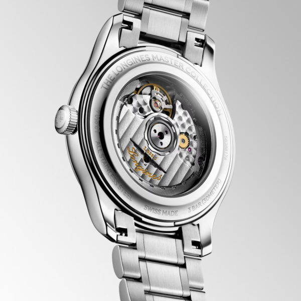 Eine Nahaufnahme der Rückseite der Longines Master Collection-Uhr, die durch den transparenten Gehäuseboden den Blick auf das Automatikwerk freigibt; dazu ein Edelstahlarmband.