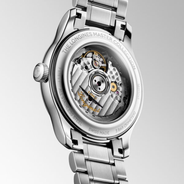 Eine Nahaufnahme der Longines Master Collection-Uhr zeigt den durchscheinenden Gehäuseboden, der den Blick auf das filigrane mechanische Uhrwerk und die Zahnräder freigibt, ergänzt durch ein silberfarbenes Edelstahlarmband.