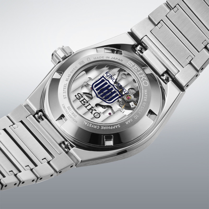 Das Bild zeigt die Rückseite der Seiko King Seiko Vanac Limited Edition mit einem Edelstahlarmband, einem transparenten Saphirglasboden, der den Blick auf das mechanische Uhrwerk freigibt, sowie dem Grand-Seiko-Löwenemblem.