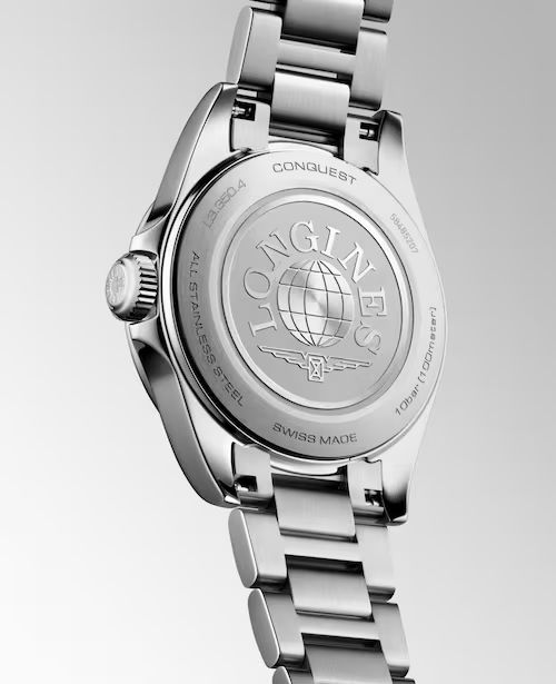 Nahaufnahme des Edelstahlbodens der Longines Conquest mit eingraviertem Markenlogo, einem Globus-Motiv und Produktangaben auf dem polierten Gehäuse und Armband.