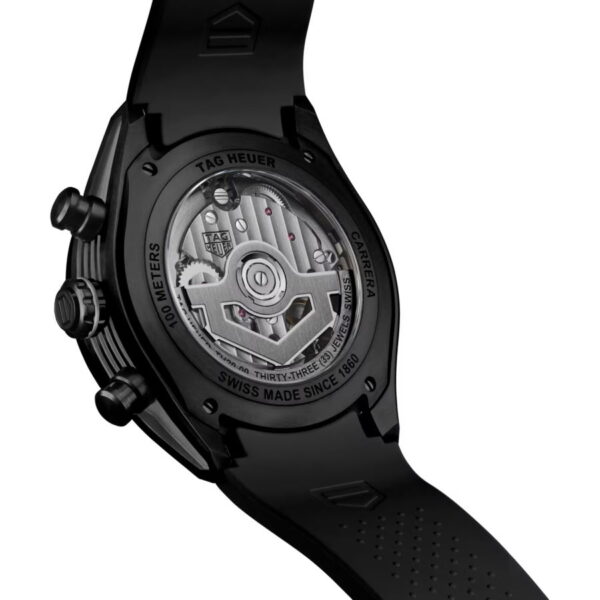 Nahaufnahme der Rückseite einer TAG Heuer Carrera Chronograph Extreme Sport-Uhr, die durch einen transparenten Gehäuseboden den Blick auf das Schweizer Automatikwerk freigibt; am Rand ist eine Gravur zu sehen, und die Uhr ist mit einem schwarzen Kautschukarmband ausgestattet.