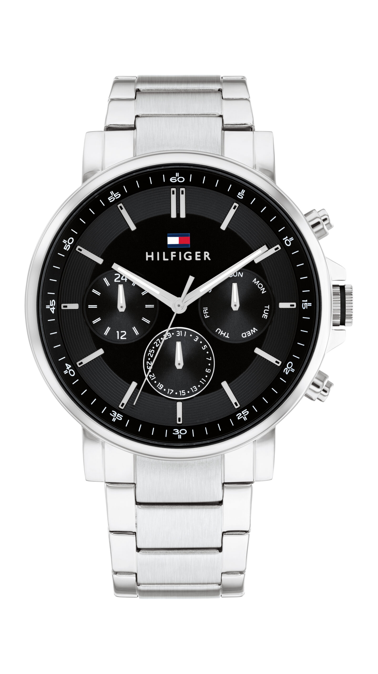Die Tommy Hilfiger Tyson ist eine silberfarbene Metallarmbanduhr mit schwarzem Zifferblatt, drei Hilfszifferblättern und dem charakteristischen Hilfiger-Logo oben. Sie verfügt über ein Edelstahlarmband und mehrere Einstellknöpfe an der Seite.