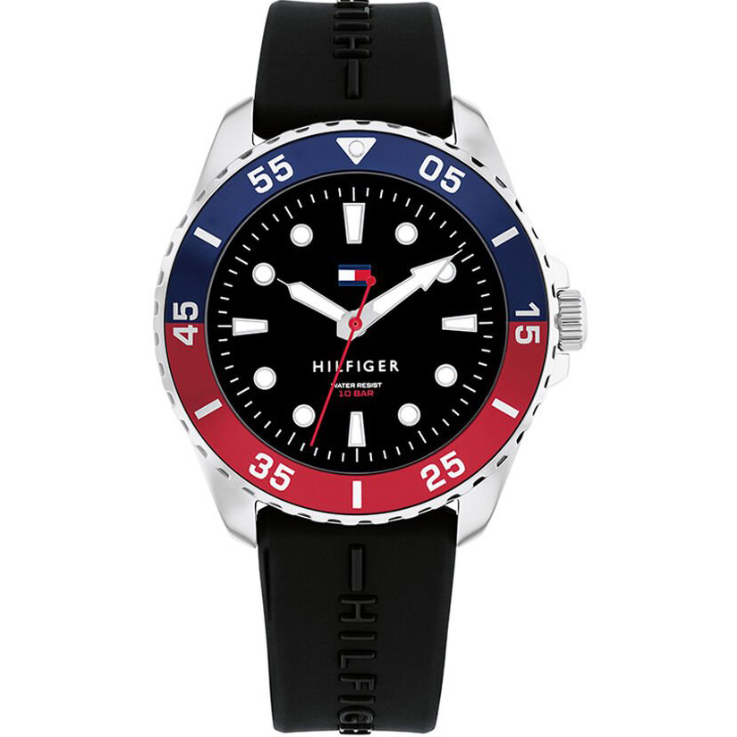 Eine schwarze Tommy-Hilfiger-Armbanduhr mit blau-roter Lünette, schwarzem Zifferblatt, weißen Indexen und einem schwarzen Silikonarmband, abgebildet vor weißem Hintergrund.