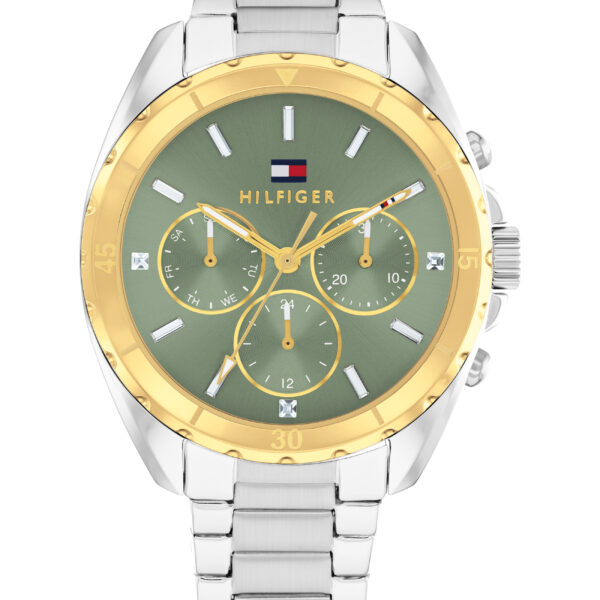 Eine Tommy Hilfiger Melli-Armbanduhr mit einem silbernen Metallgliederarmband, grünem Zifferblatt, goldener Lünette, drei Hilfszifferblättern und dem Markennamen „Hilfiger“, der auf dem Zifferblatt unterhalb eines kleinen Logos zu sehen ist.