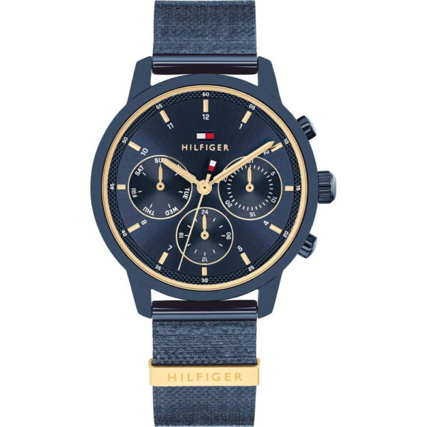 Die Tommy Hilfiger Blake ist eine marineblaue und goldfarbene Uhr mit einem Stoffarmband, drei Hilfszifferblättern und goldenen Akzenten. Auf dem Zifferblatt und der Schließe ist der Markenname „Hilfiger“ zu sehen, wobei oben ein kleines rot-weiß-blaues Logo angebracht ist.