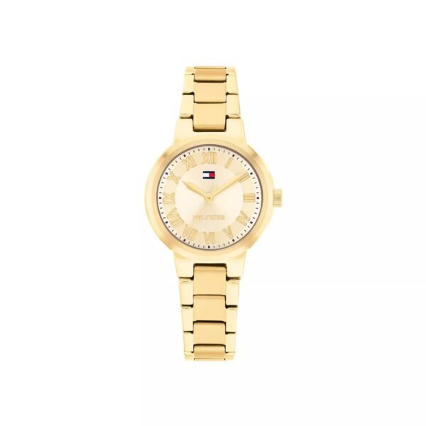Eine goldene Armbanduhr der Marke Tommy Hilfiger „Becca“ mit einem metallischen Armband, römischen Ziffern und einem kleinen rot-weiß-blauen Tommy-Hilfiger-Logo auf dem Zifferblatt ist vor einem weißen Hintergrund abgebildet.