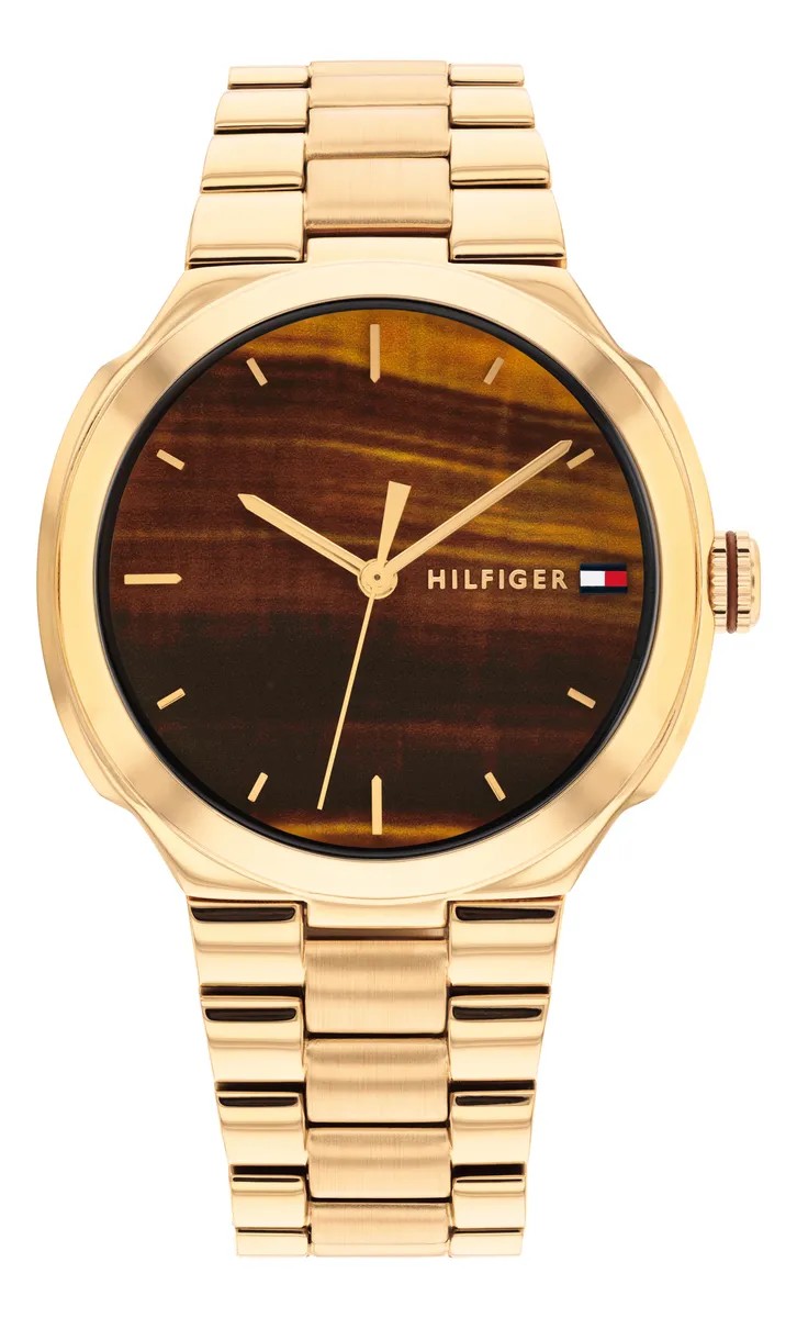 Tommy Hilfiger Georgia Armbanduhr mit einem goldenen Metallgliederarmband, einem braunen Zifferblatt mit Holzoptik, minimalistischem Design, goldenen Zeigern und dem „HILFIGER“-Logo, das durch eine kleine rot-weiß-blaue Flagge auf der rechten Seite akzentuiert wird.