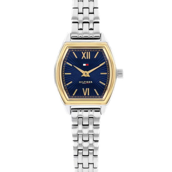 Eine Tommy Hilfiger Norah-Armbanduhr mit einem silberfarbenen Metallgliederarmband, blauem Zifferblatt, goldfarbener Lünette, römischen Ziffern bei 12 und 6 Uhr sowie dem Markenlogo oberhalb der Zifferblattmitte.