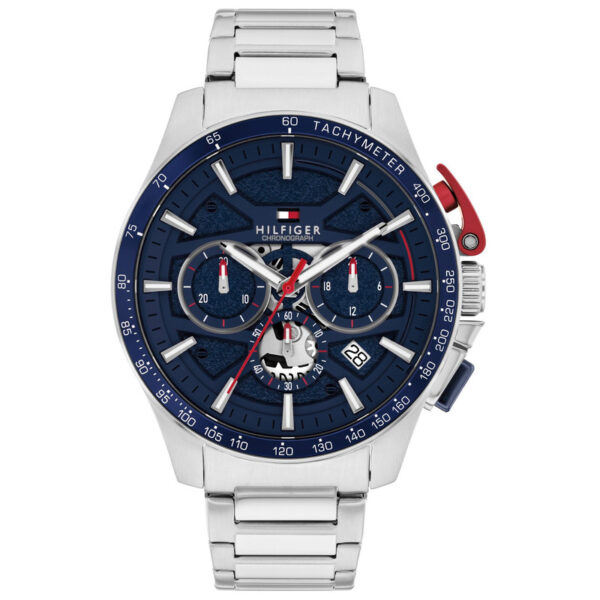 Eine Chronographenuhr der Marke Tommy Hilfiger Bank in Silber mit blauer Lünette, drei Hilfszifferblättern, einem Datumsfenster, Tachymeter-Skala, einem Edelstahlarmband und markanten roten Akzenten an der Seite.