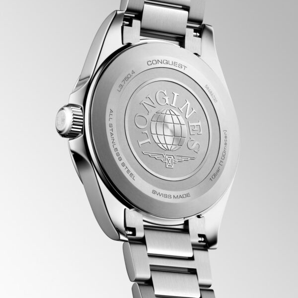 Die Rückseite der Longines Conquest-Armbanduhr aus Edelstahl mit eingraviertem Schriftzug, einem Globus-Emblem und einem Metallarmband, fotografiert vor einem neutralen Hintergrund.