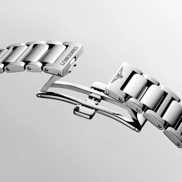 Eine Nahaufnahme des silbernen Metallarmbands der Longines Conquest mit Faltschließe, auf dessen polierten Gliedern das Longines-Logo und gravierte Details vor einem hellen Hintergrund zu sehen sind.