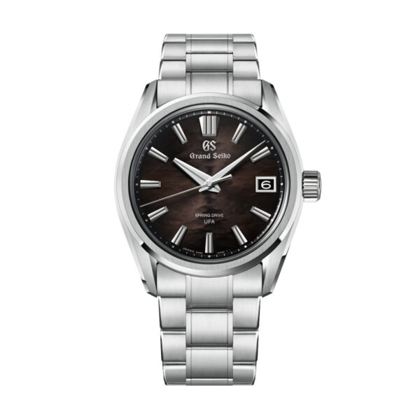 Eine Grand Seiko Evolution 9 Lake Suwa Black Armbanduhr aus Edelstahl mit einem dunkelbraunen Zifferblatt mit silbernen Indexen und Zeigern, einem Datumsfenster bei 3 Uhr und einem Metallarmband. Auf dem Zifferblatt sind die Aufschriften „Spring Drive“ und „UFA“ zu sehen.