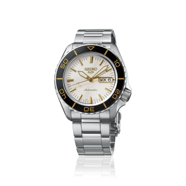 Seiko 5 Sports Armbanduhr aus Edelstahl mit weißem Zifferblatt mit Sonnenstrahl-Finish, goldfarbenen Indexen und Zeigern, einer schwarzen drehbaren Lünette sowie einer Tages- und Datumsanzeige bei 3 Uhr.